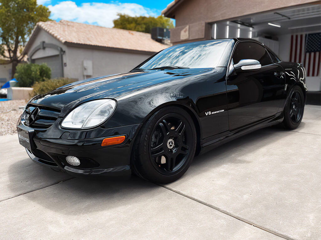 Black Mercedes-Benz SLK-Class with ceramic coating parked in a residential driveway.